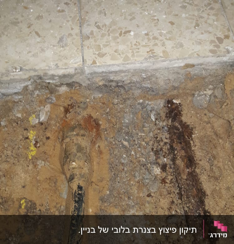 צינור מתכת חלוד באדמה ליד רצפה